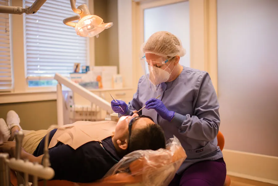 Una higienista realizando una limpieza dental